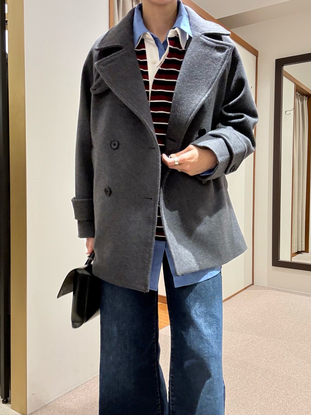 グレー系のピーコート、ブルー系のシャツ/ブラウス、レッド系のTシャツ/カットソーを着用したレディースの秋コーディネートの6枚目の写真