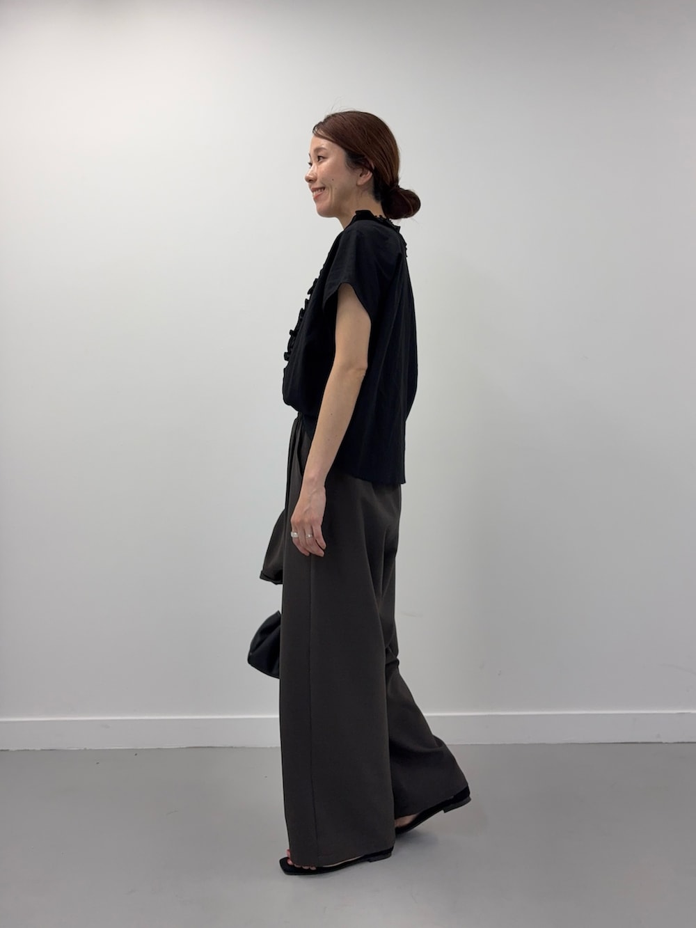 ブラック系のシャツ/ブラウス、ブラック系のショルダーバッグ、ブラック系のサンダルを着用したレディースの春コーディネートの6枚目の写真