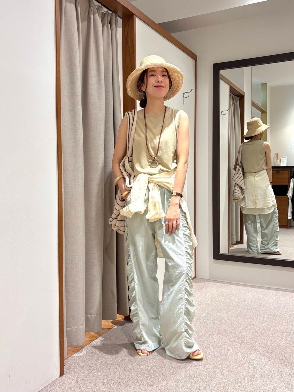 グリーン系のその他パンツ、ホワイト系のシャツ/ブラウス、ベージュ系のタンクトップを着用したレディースの夏コーディネートの4枚目の写真