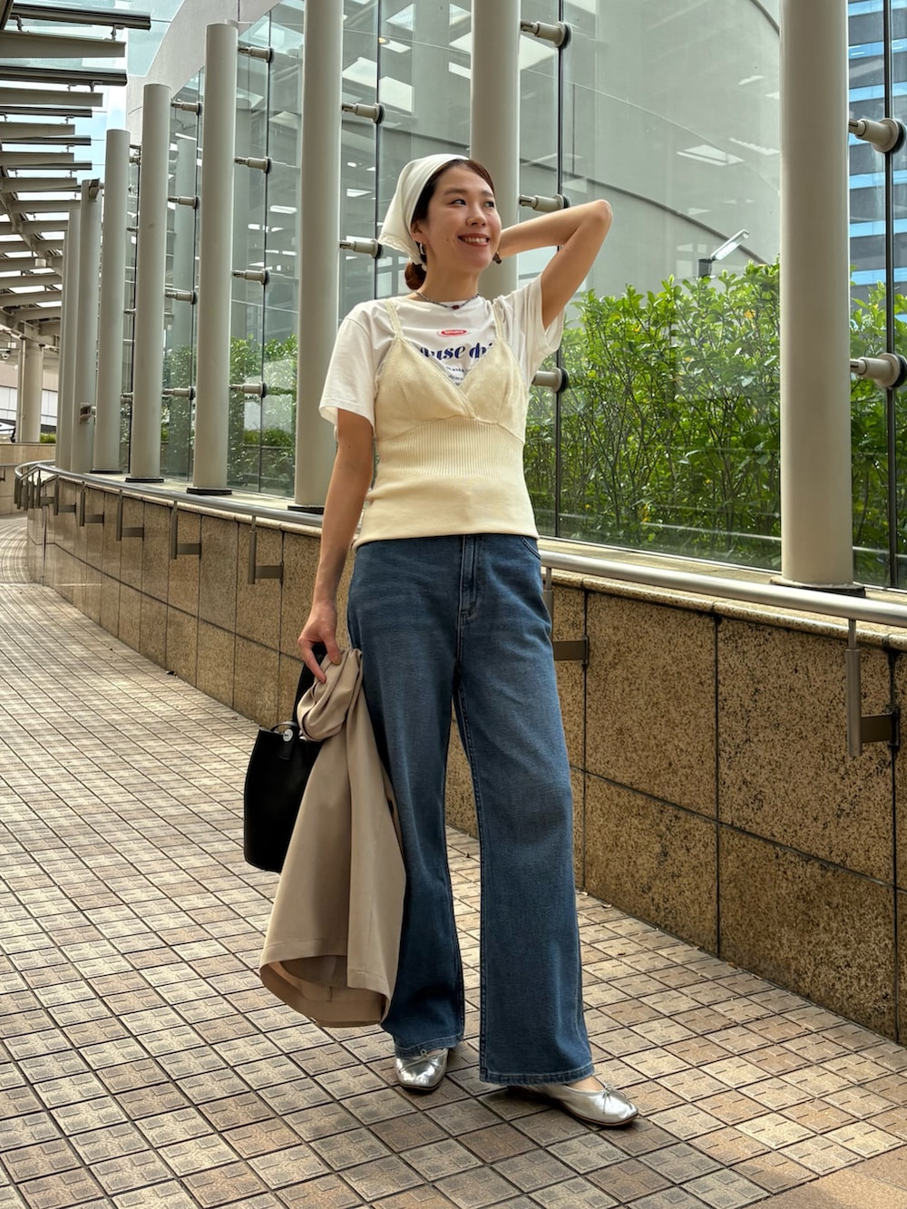 ブルー系のデニムパンツ、ベージュ系のその他アウター、ブラック系のハンドバッグを着用したレディースの春コーディネートの7枚目の写真