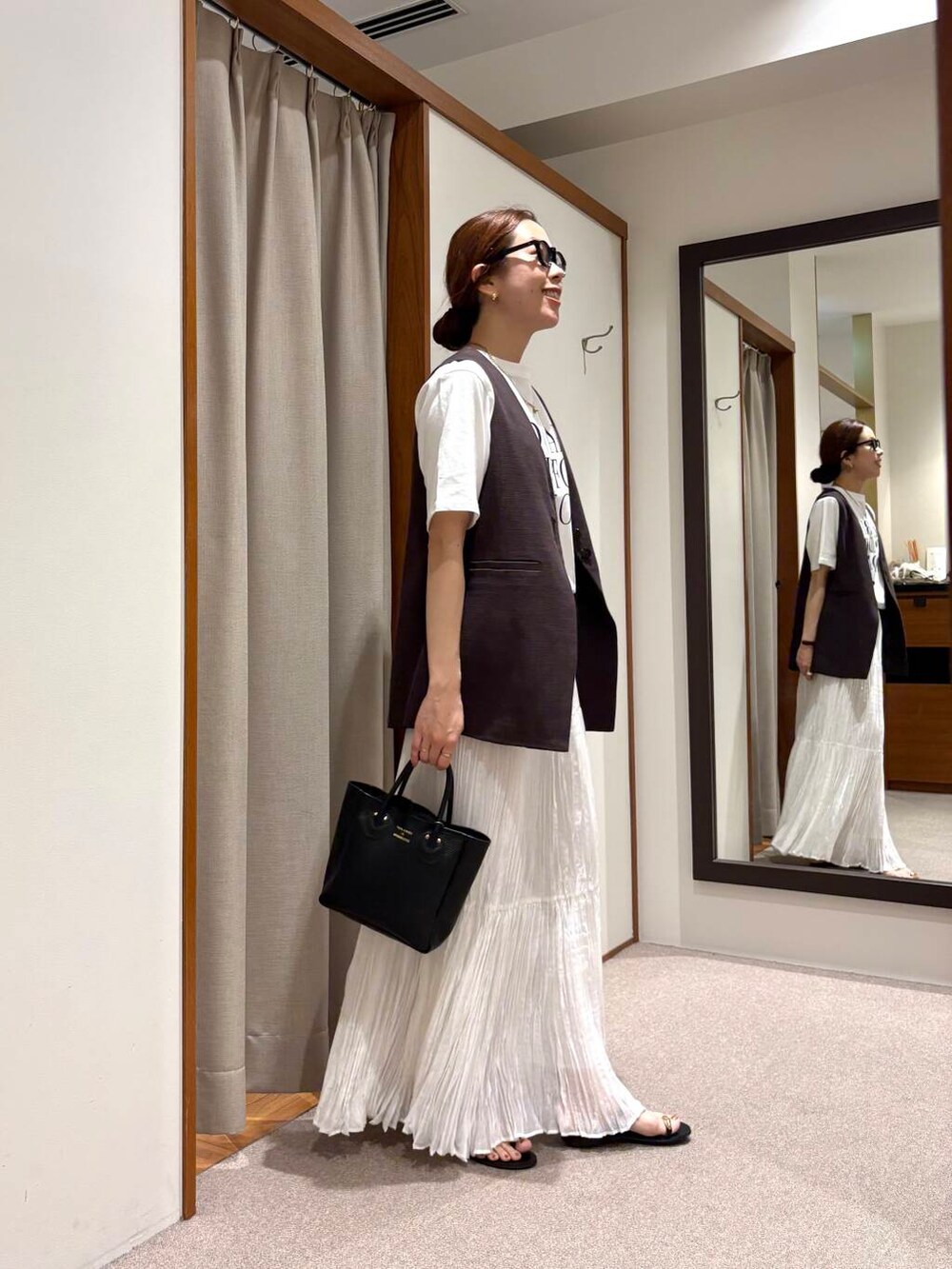 その他のTシャツ/カットソー、ホワイト系のスカート、ブラウン系のベストを着用したレディースの夏コーディネートの4枚目の写真