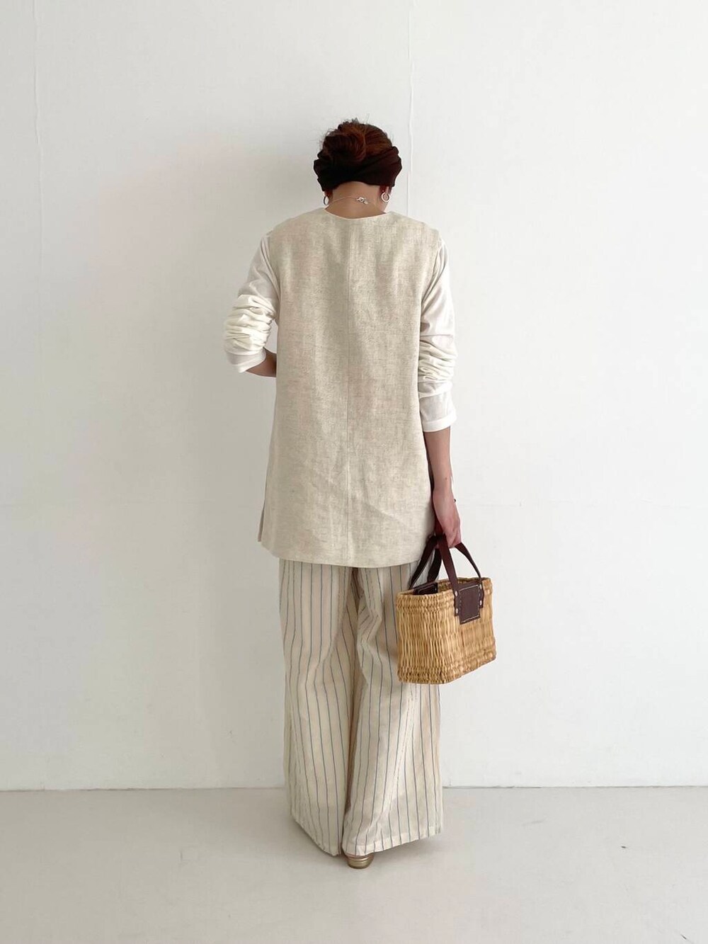 ベージュ系のベスト、ブラウン系のかごバッグ、ベージュ系のその他パンツを着用したレディースの春コーディネートの3枚目の写真