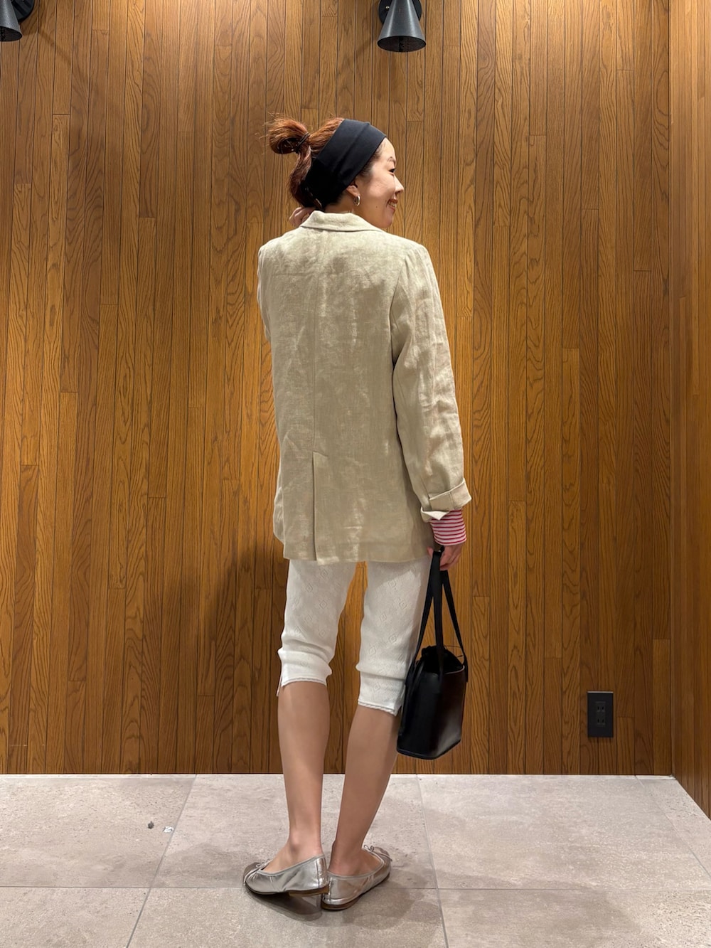 ベージュ系のその他アウター、レッド系のTシャツ/カットソー、ブラック系のハンドバッグを着用したレディースの春コーディネートの3枚目の写真