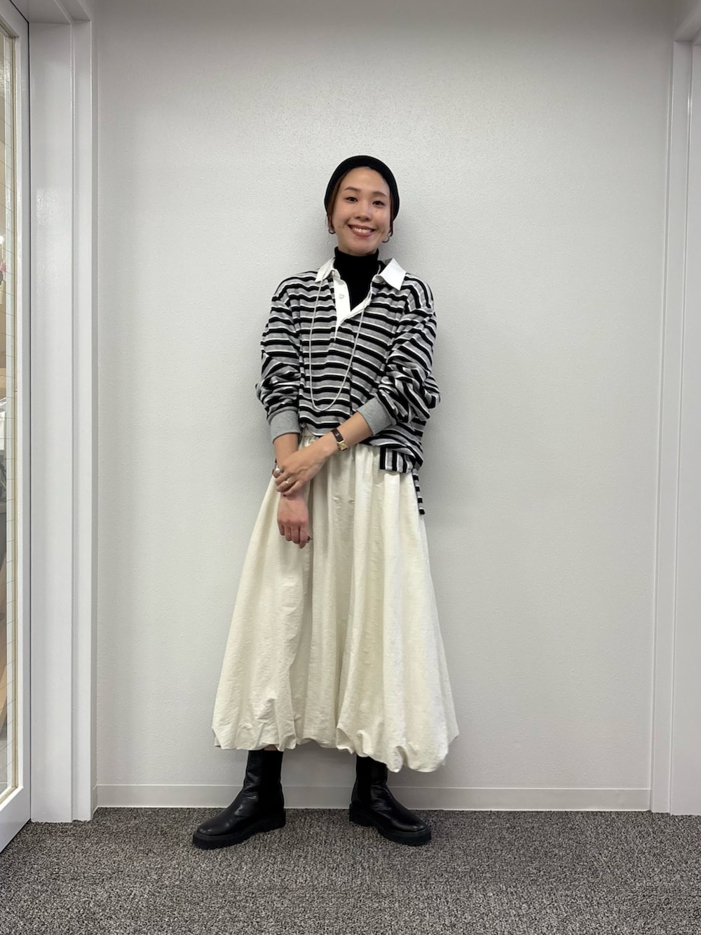 ホワイト系のスカート、ブラック系のニット/セーター、レッド系のTシャツ/カットソーを着用したレディースの秋コーディネートの4枚目の写真