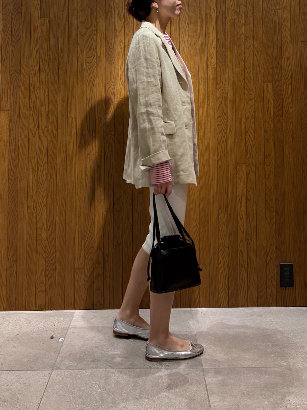 ベージュ系のその他アウター、レッド系のTシャツ/カットソー、ブラック系のハンドバッグを着用したレディースの春コーディネートの4枚目の写真