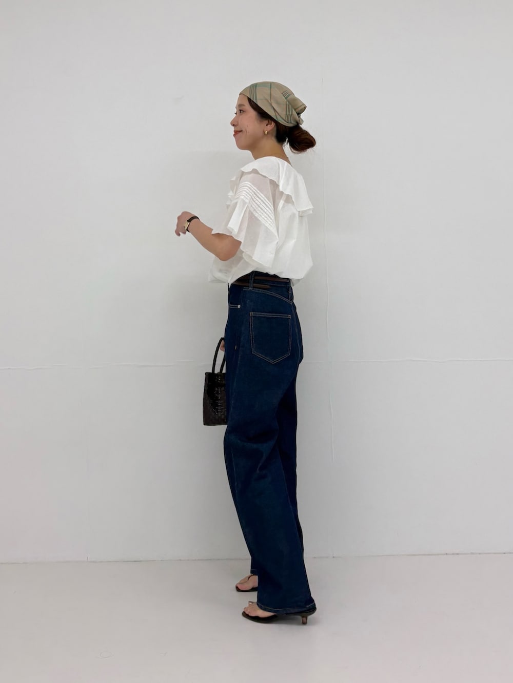 ホワイト系のシャツ/ブラウス、ブルー系のデニムパンツ、ブラウン系のトートバッグを着用したレディースの夏コーディネートの2枚目の写真