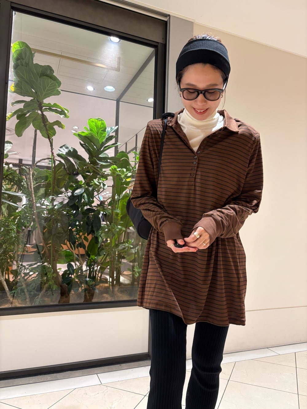 ブラウン系のポロシャツ、ブラック系のその他パンツ、ブラック系のハンドバッグを着用したレディースの秋コーディネートの8枚目の写真