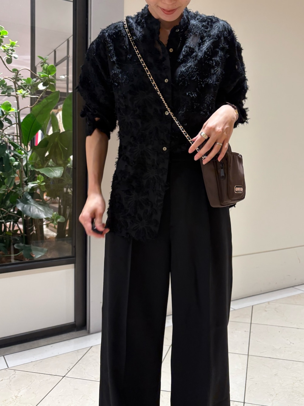 ブラック系のシャツ/ブラウス、ブラック系のスラックス、ブラウン系のショルダーバッグを着用したレディースの冬コーディネートの5枚目の写真