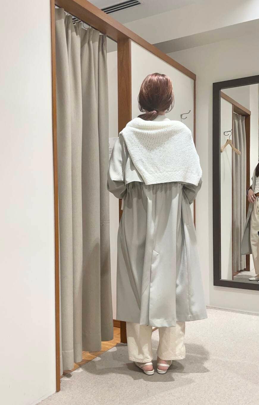 イエロー系のTシャツ/カットソー、グリーン系のトレンチコート、ホワイト系のニット/セーターを着用したレディースの春コーディネートの3枚目の写真