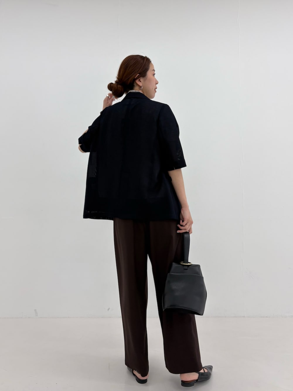 ブラック系のその他アウター、ホワイト系のシャツ/ブラウス、ブラウン系のその他パンツを着用したレディースの春コーディネートの3枚目の写真