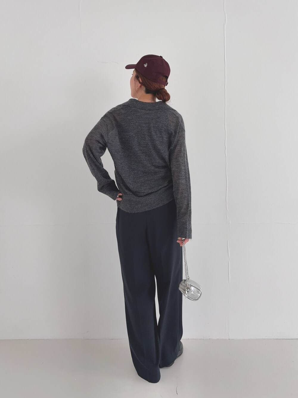 ブラック系のその他パンツ、グレー系のニット/セーター、レッド系のキャップを着用したレディースの夏コーディネートの4枚目の写真