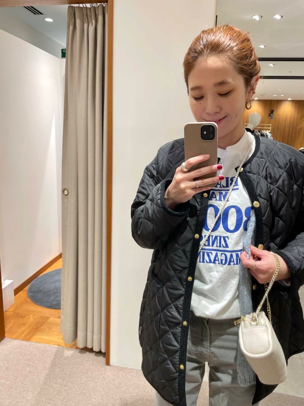 ブラック系のダウンジャケット/コート、ブラック系のショルダーバッグ、ホワイト系のTシャツ/カットソーを着用したレディースの冬コーディネートの3枚目の写真