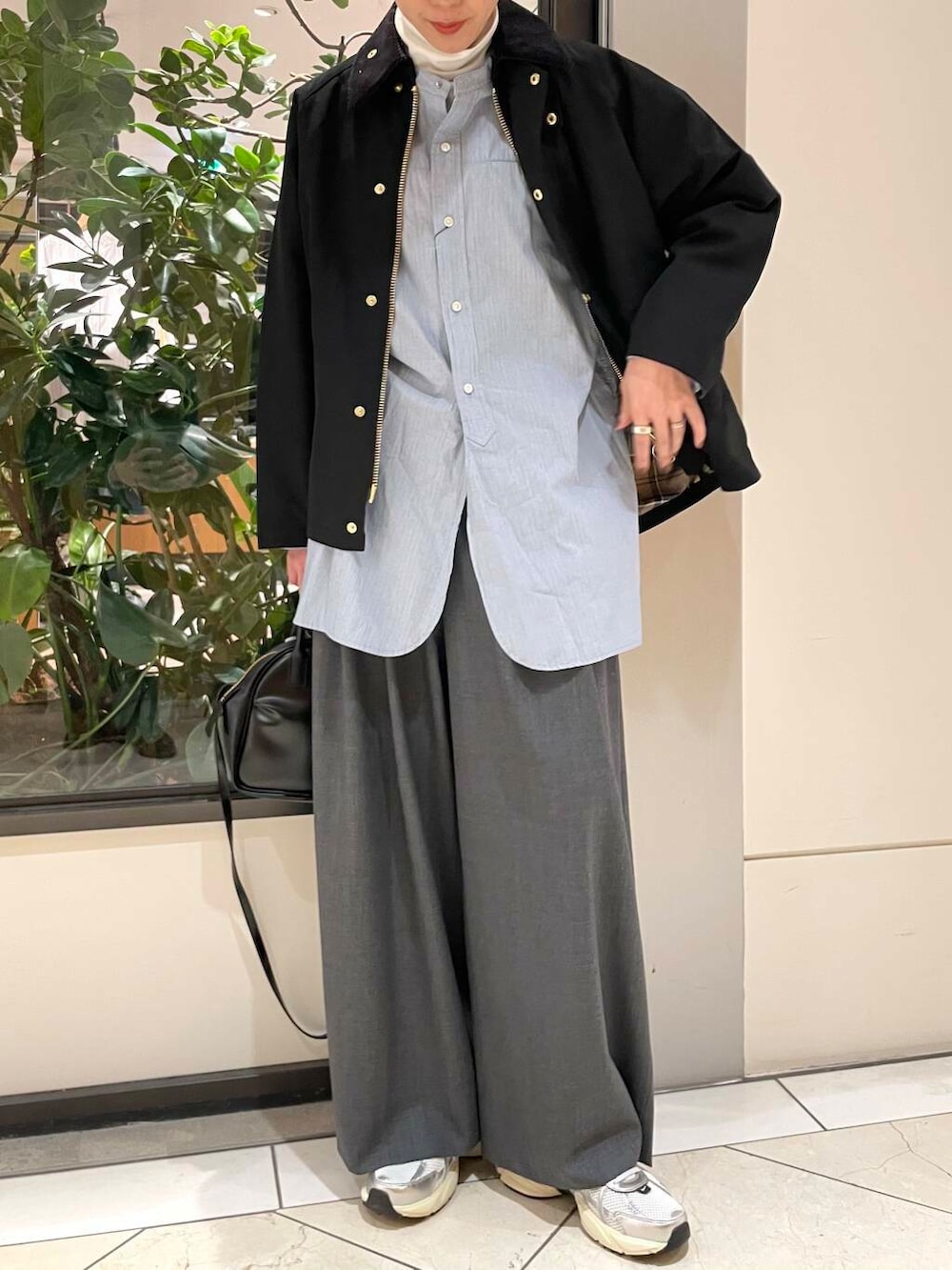 ブラック系のショルダーバッグ、ブルー系のTシャツ/カットソー、ホワイト系のスニーカーを着用したレディースの冬コーディネートの5枚目の写真