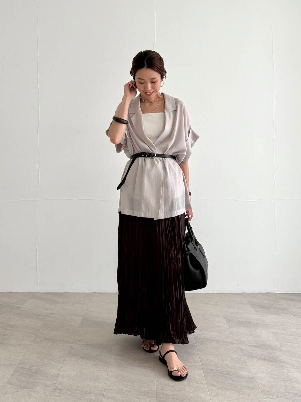 ホワイト系のキャミソール、ブラウン系のスカート、ブラック系のサンダルを着用したレディースの夏コーディネートの6枚目の写真