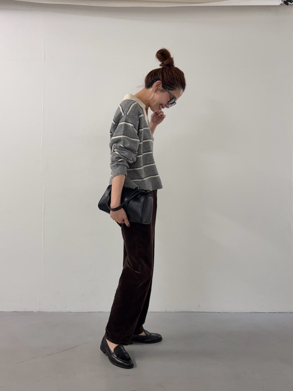 グレー系のニット/セーター、ブラウン系のその他パンツ、ブラック系のハンドバッグを着用したレディースの秋コーディネートの4枚目の写真