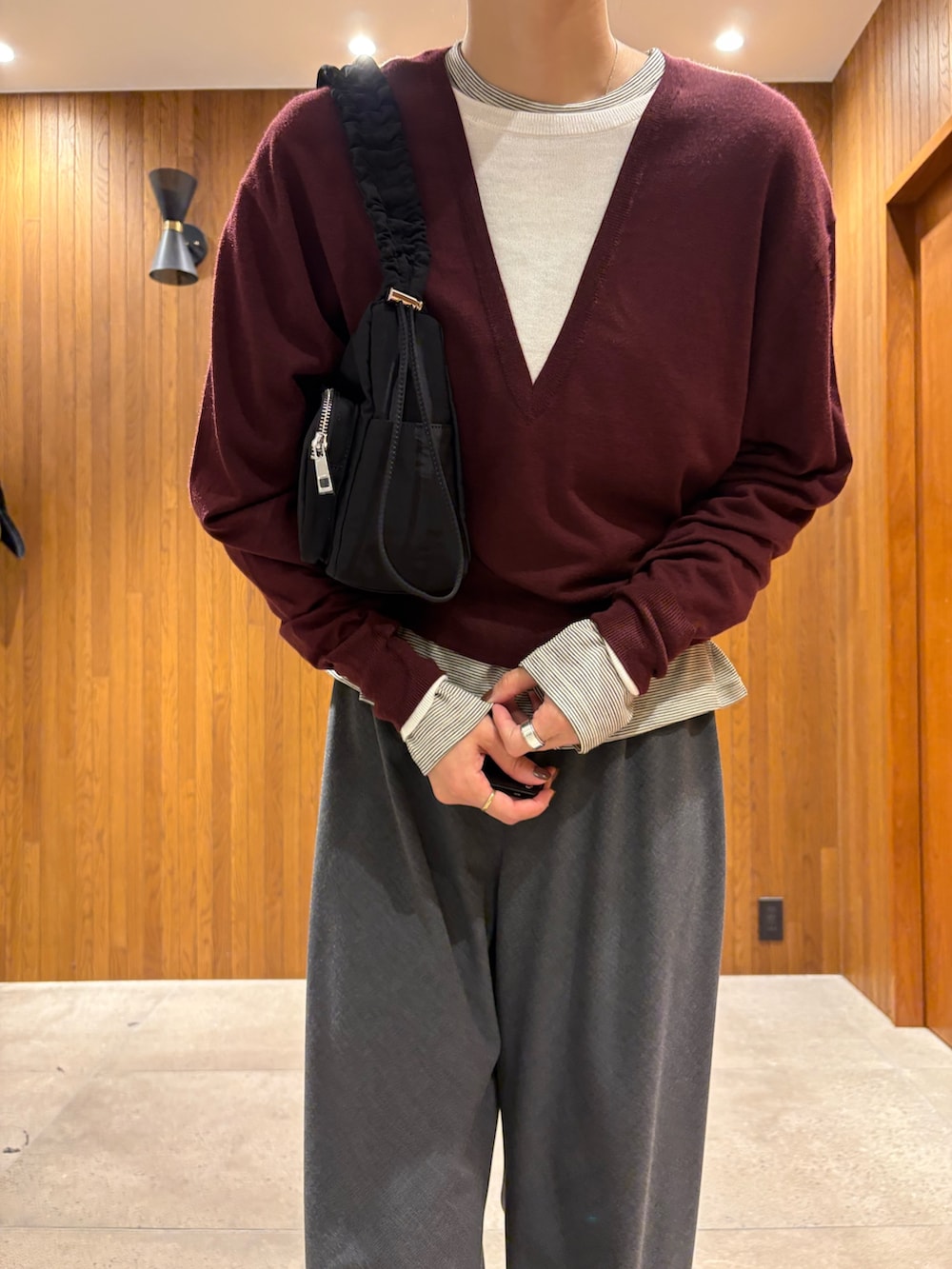 レッド系のニット/セーター、ホワイト系のTシャツ/カットソー、グレー系のその他パンツを着用したレディースの秋コーディネートの5枚目の写真