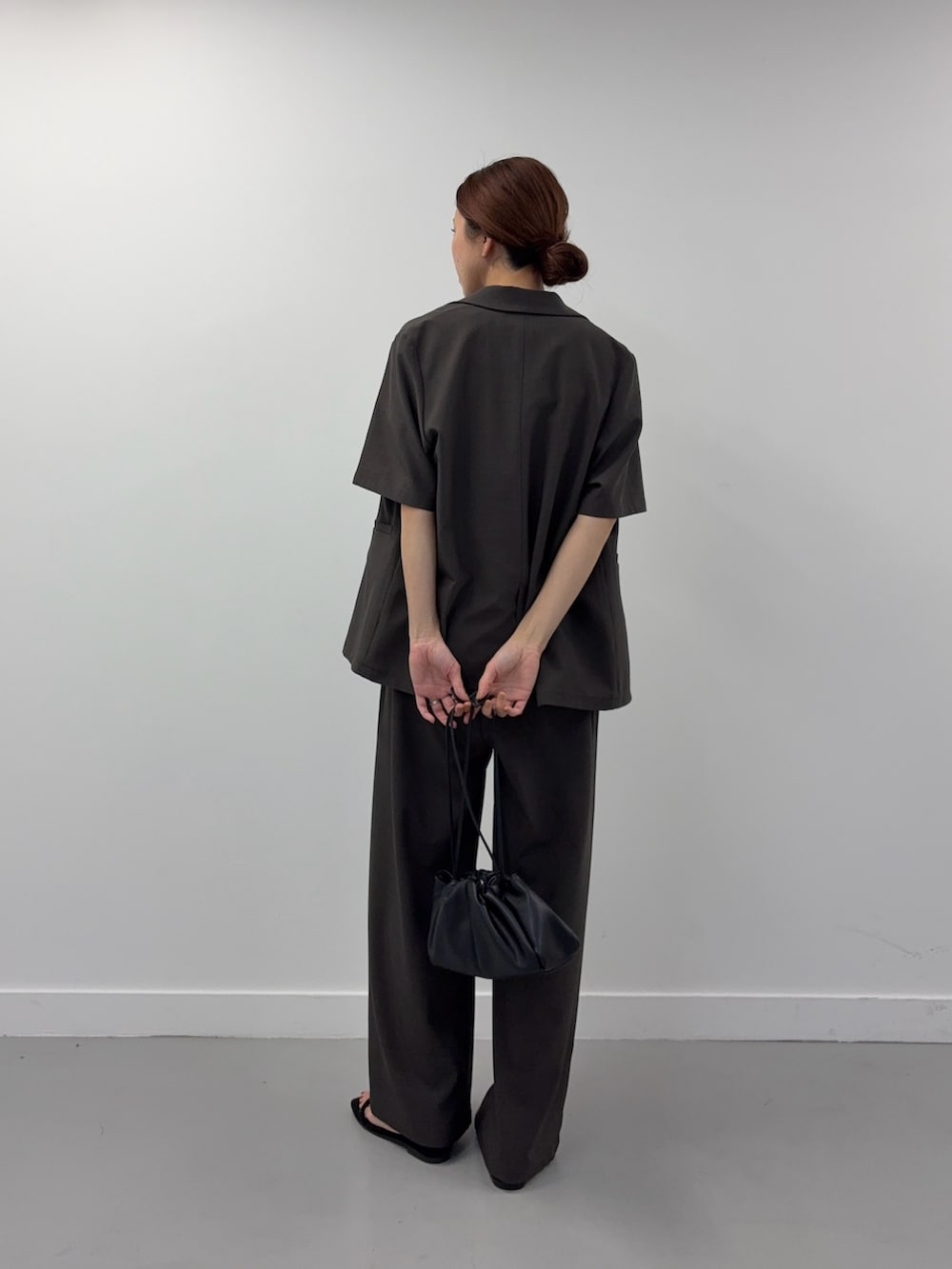 ブラック系のシャツ/ブラウス、ブラック系のショルダーバッグ、ブラック系のサンダルを着用したレディースの春コーディネートの3枚目の写真
