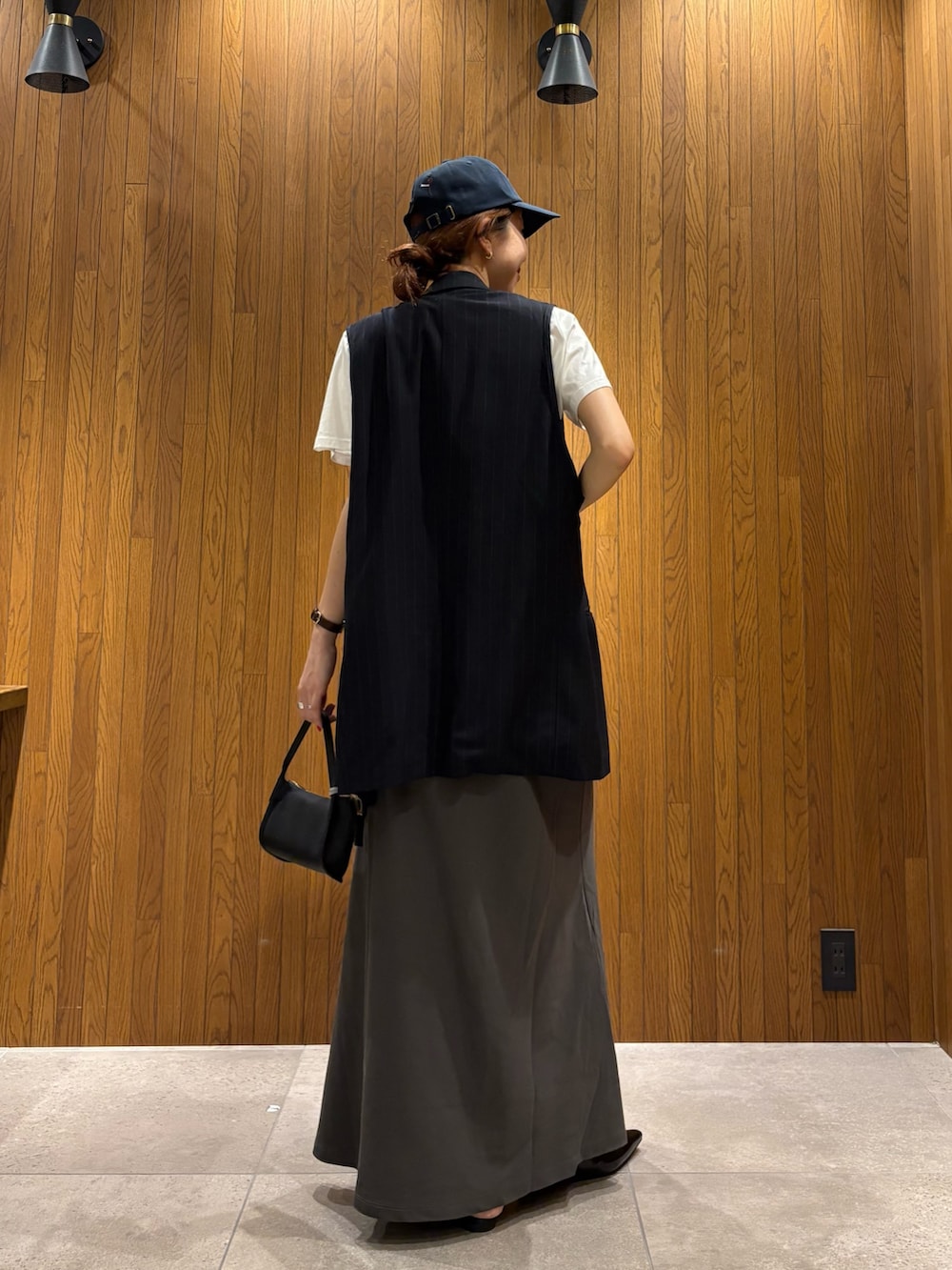 グレー系のスカート、その他のTシャツ/カットソー、ブラック系のハンドバッグを着用したレディースの春コーディネートの3枚目の写真