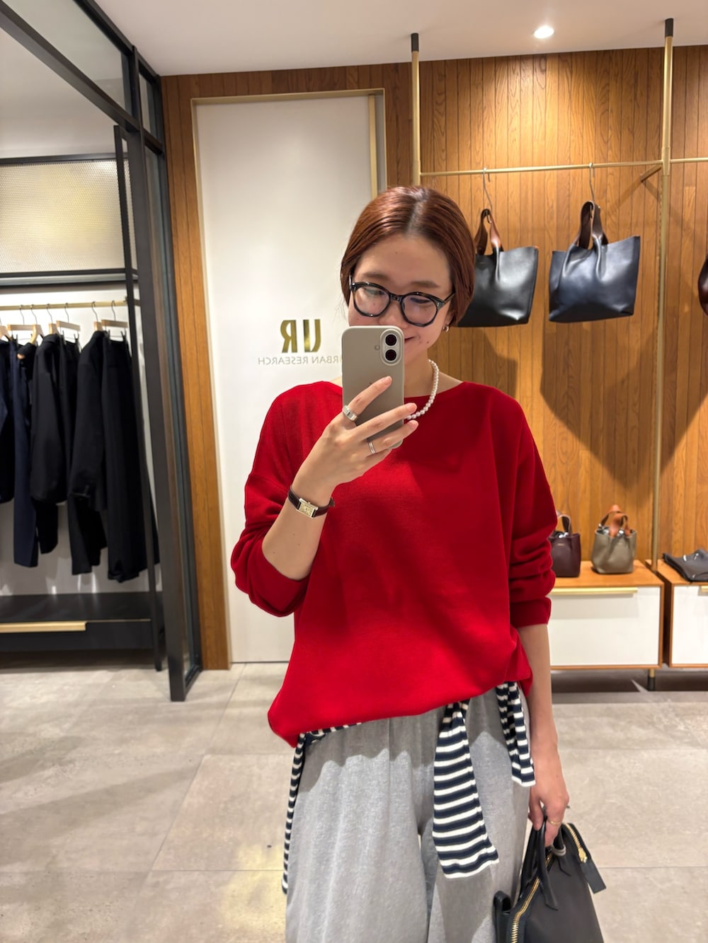 レッド系のニット/セーター、ブルー系のTシャツ/カットソー、グレー系のその他パンツを着用したレディースの秋コーディネートの8枚目の写真