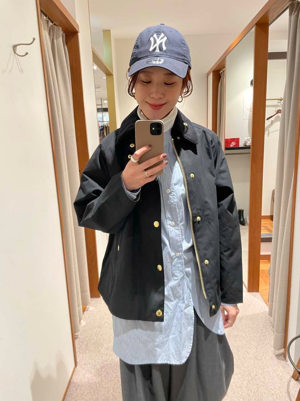 ブラック系のショルダーバッグ、ブルー系のTシャツ/カットソー、ホワイト系のスニーカーを着用したレディースの冬コーディネートの6枚目の写真