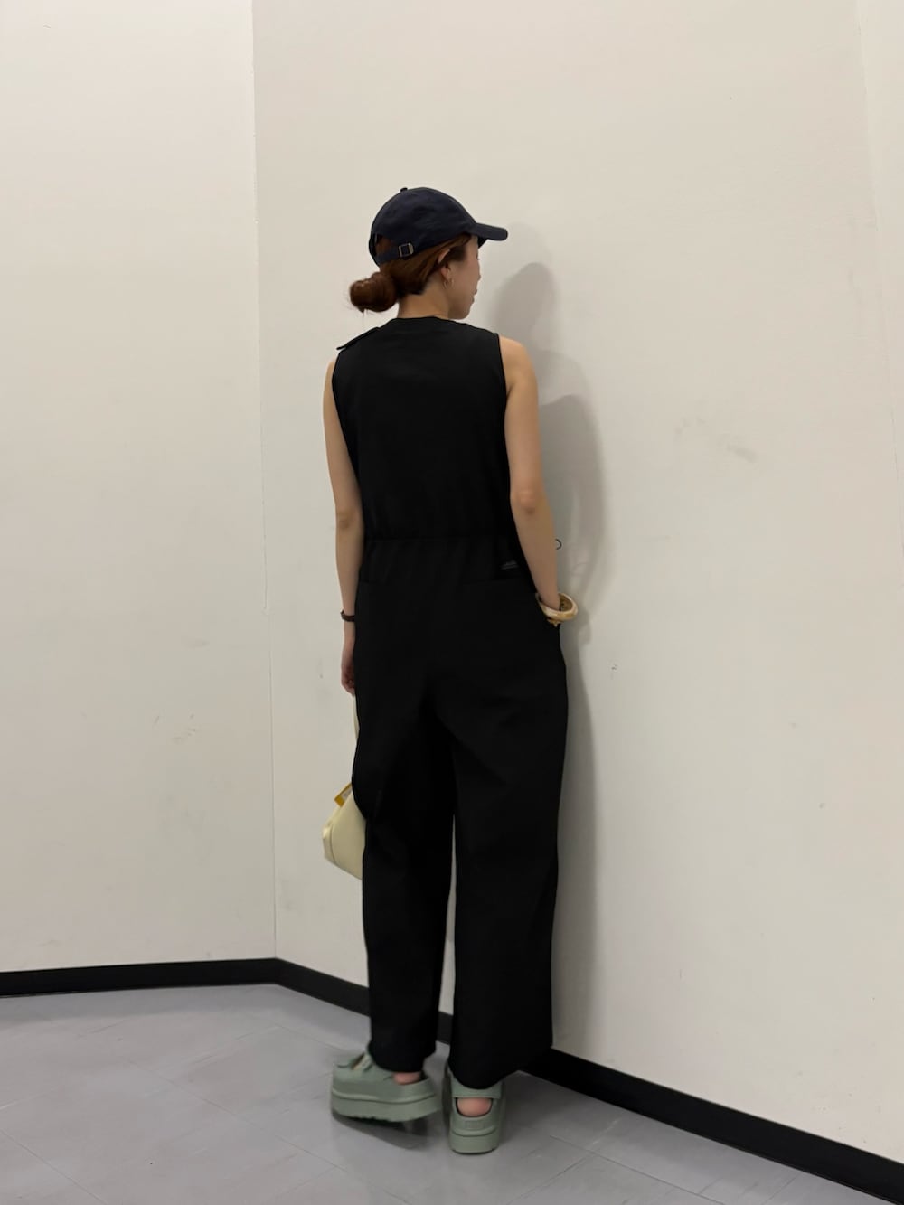 ブラック系のその他パンツ、ホワイト系のハンドバッグ、ブルー系のキャップを着用したレディースの春コーディネートの3枚目の写真