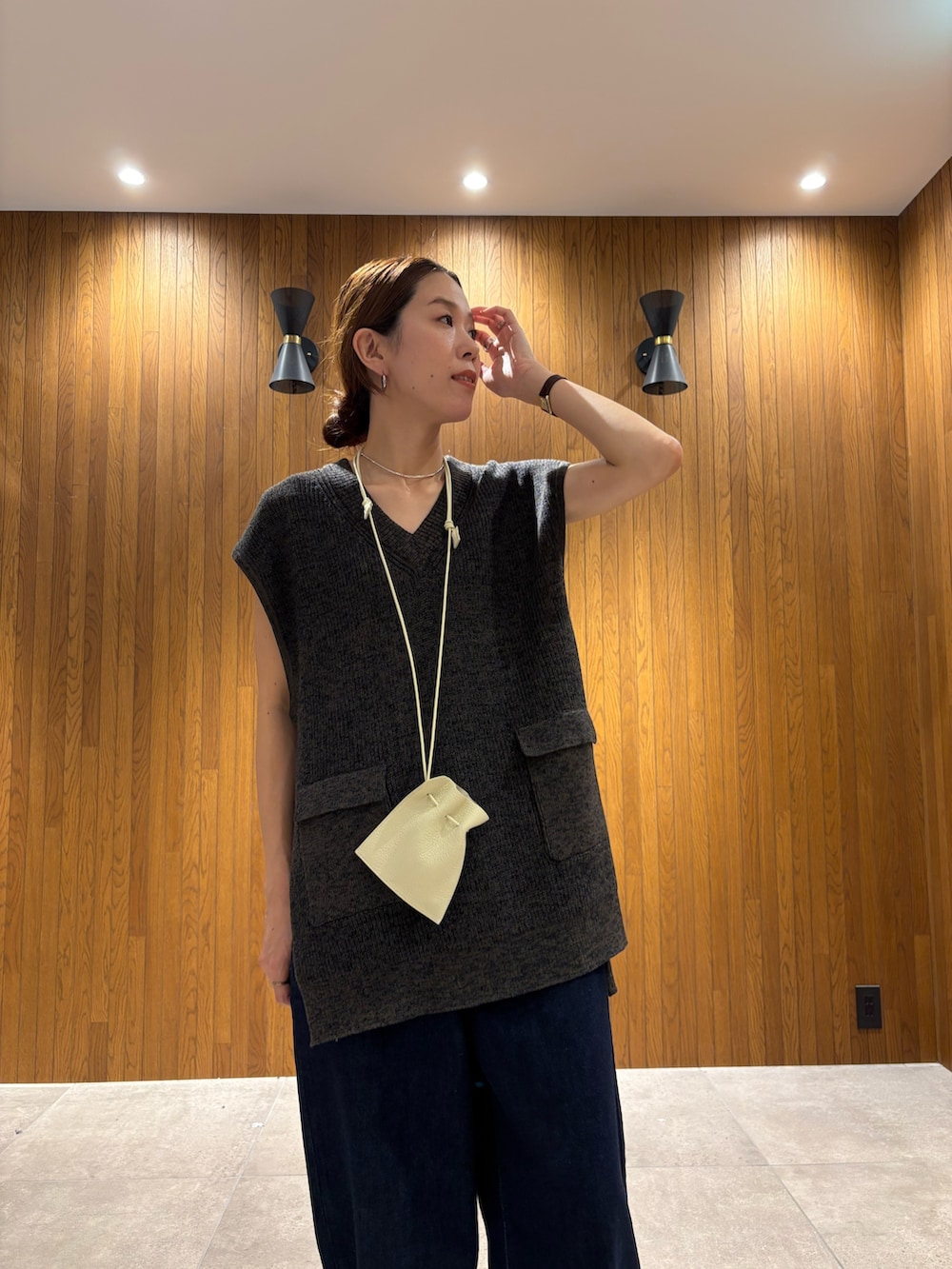 ブラック系のデニムパンツ、ブラック系のニット/セーター、ホワイト系のポーチを着用したレディースの夏コーディネートの7枚目の写真