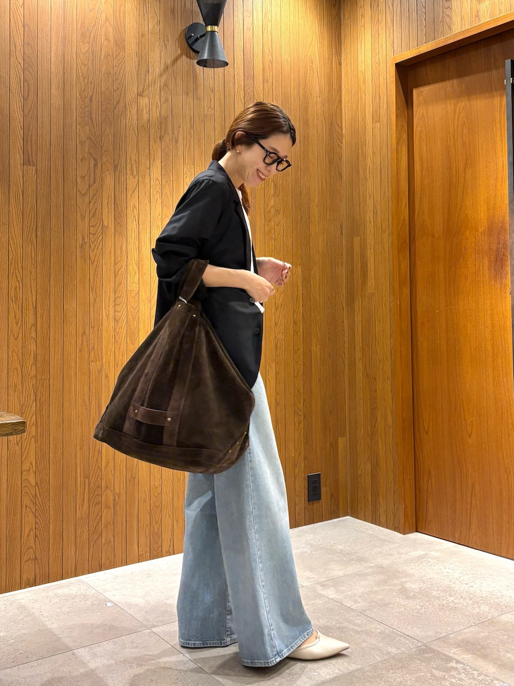 ブルー系のデニムパンツ、ホワイト系のTシャツ/カットソー、ブラック系のテーラードジャケットを着用したレディースの夏コーディネートの2枚目の写真