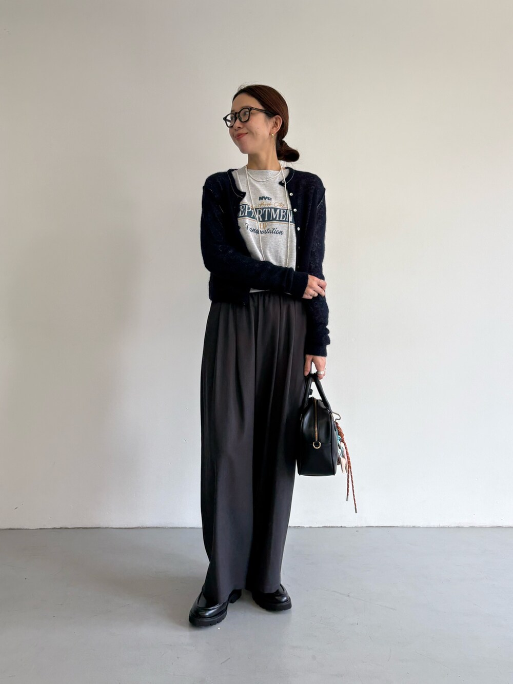 ブラック系のダウンジャケット/コート、グレー系のその他パンツ、ブラック系のローファーを着用したレディースの冬コーディネートの8枚目の写真