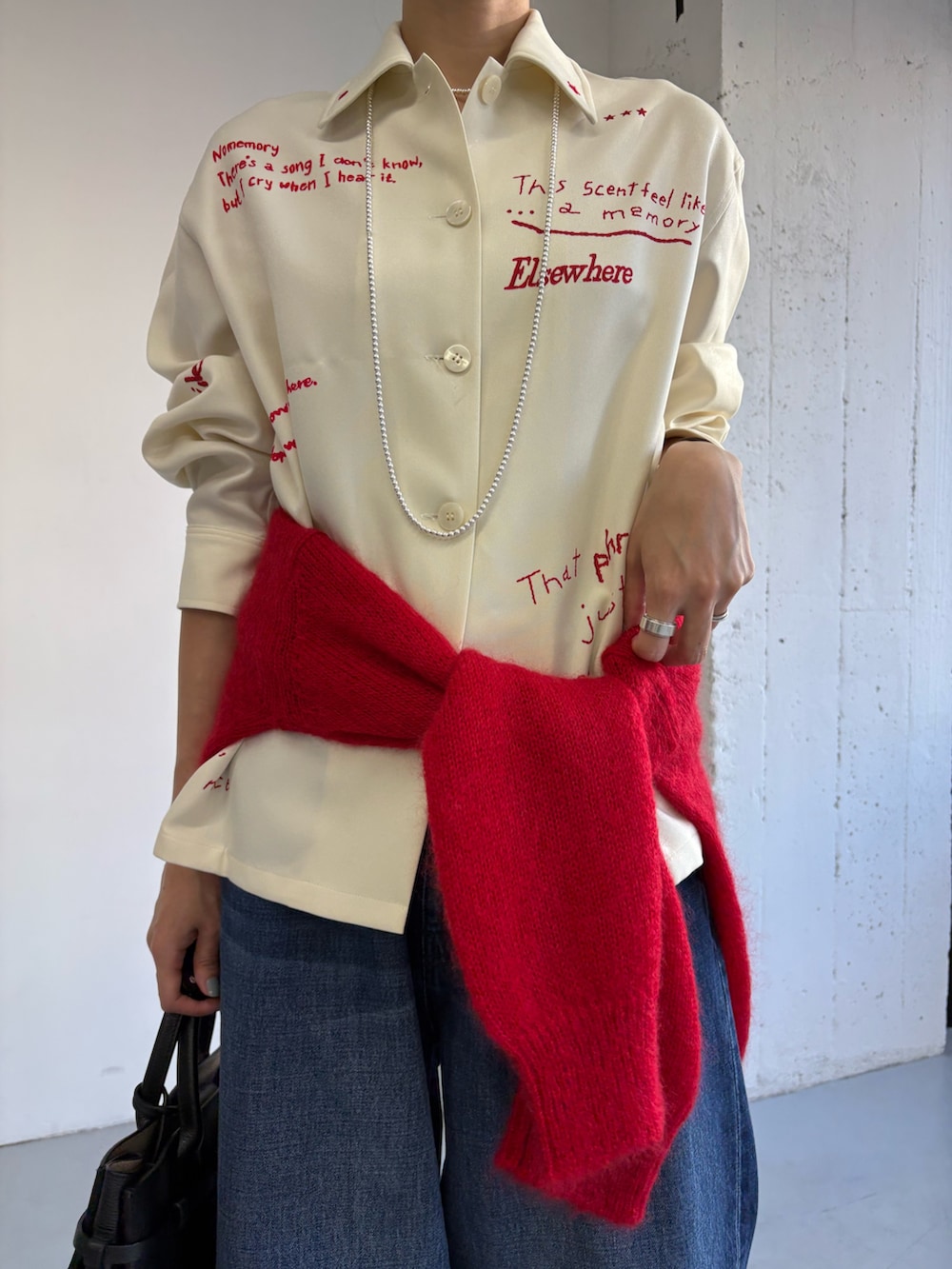 ホワイト系のTシャツ/カットソー、ブラック系のトートバッグ、レッド系のニット/セーターを着用したレディースの秋コーディネートの3枚目の写真