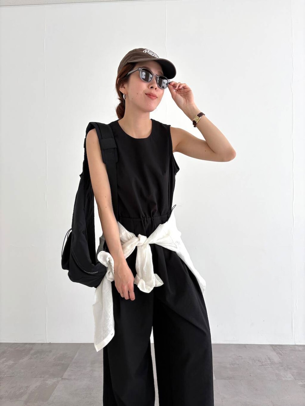 ホワイト系のシャツ/ブラウス、ブラック系のバックパック/リュック、ブラック系のサロペット/オーバーオールを着用したレディースの春コーディネートの6枚目の写真