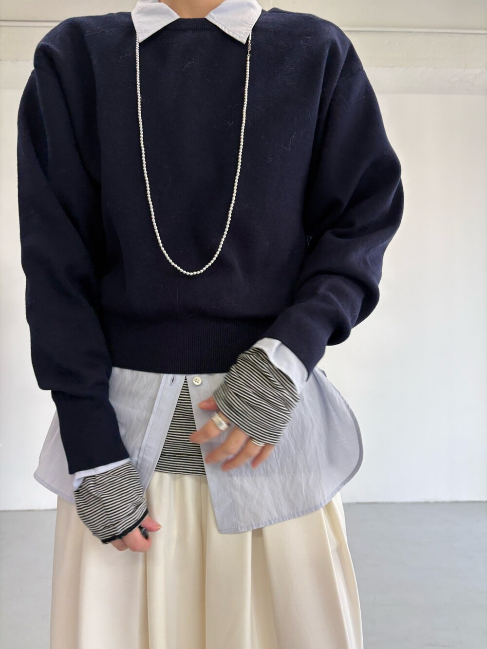 グレー系のピーコート、ホワイト系のその他パンツ、シルバー系のショルダーバッグを着用したレディースの冬コーディネートの9枚目の写真