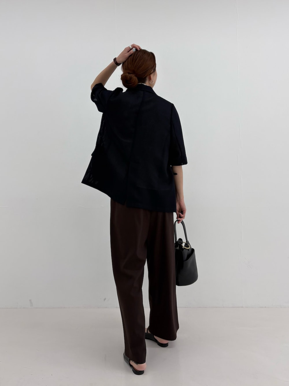 ブラック系のその他アウター、ホワイト系のシャツ/ブラウス、ブラウン系のその他パンツを着用したレディースの春コーディネートの4枚目の写真