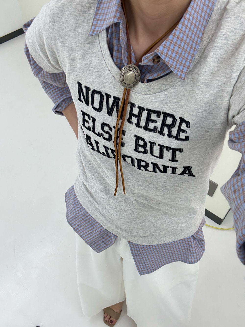 ベージュ系のその他アウター、ブルー系のシャツ/ブラウス、ホワイト系のデニムパンツを着用したレディースの春コーディネートの9枚目の写真