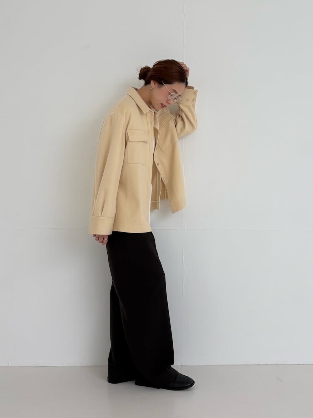 ホワイト系のニット/セーター、ブラウン系のその他パンツ、ゴールド系のメガネを着用したレディースの秋コーディネートの5枚目の写真