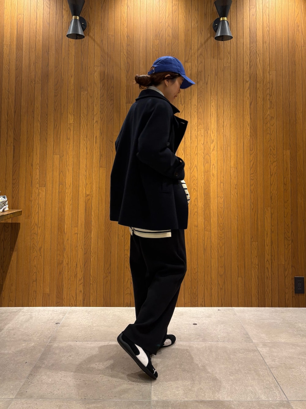 ブラック系のカーディガン/ボレロ、グレー系のスウェット、グレー系のピーコートを着用したレディースの秋コーディネートの4枚目の写真