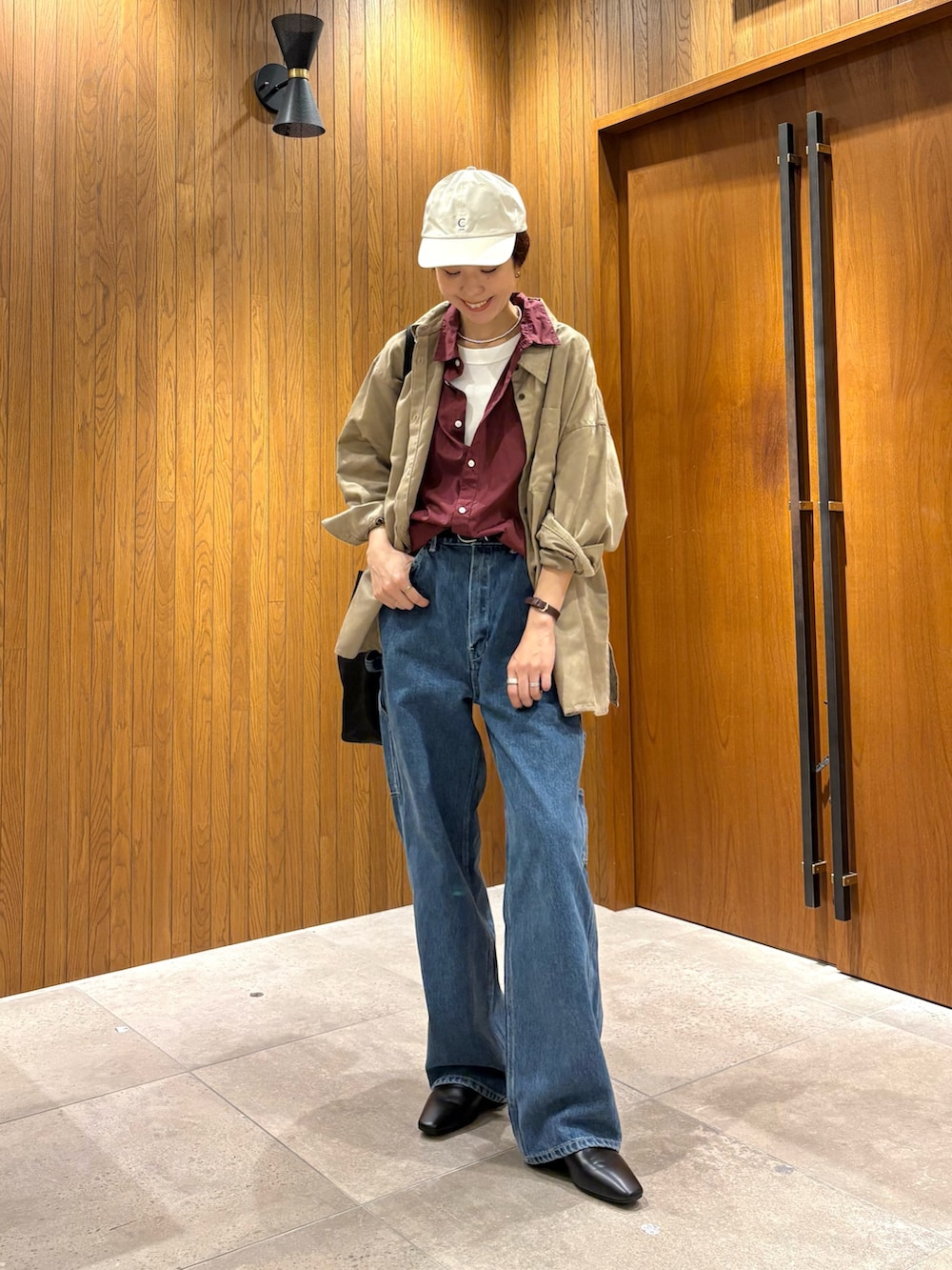 ブルー系のデニムパンツ、レッド系のシャツ/ブラウス、ブラック系のローファーを着用したレディースの夏コーディネートの2枚目の写真