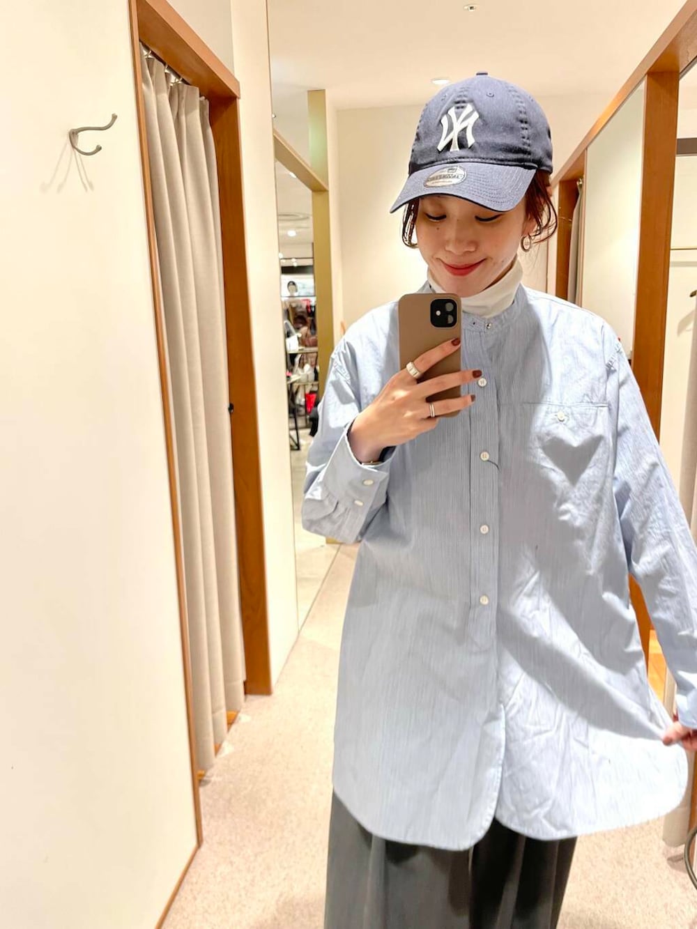 ブラック系のショルダーバッグ、ブルー系のTシャツ/カットソー、ホワイト系のスニーカーを着用したレディースの冬コーディネートの8枚目の写真