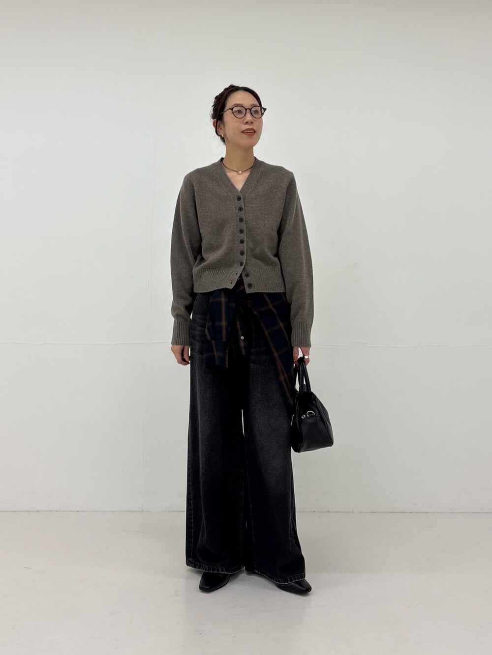 ホワイト系のシャツ/ブラウス、ブラック系のデニムパンツ、ブラック系のハンドバッグを着用したレディースの秋コーディネートの4枚目の写真