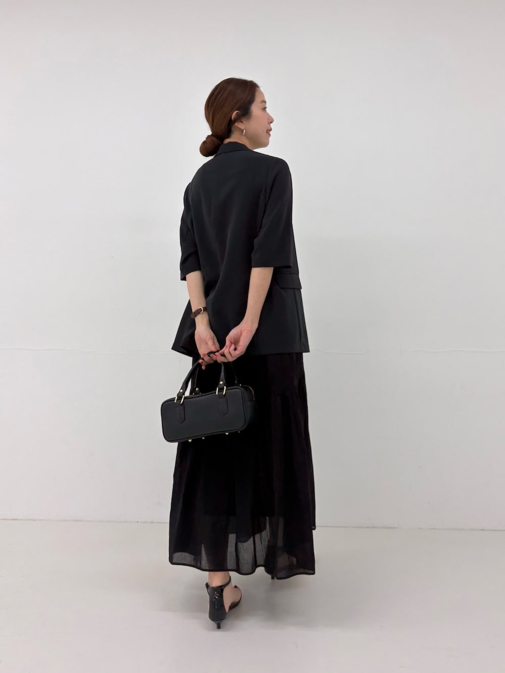 ブラック系のその他アウター、ブラック系のハンドバッグ、ブラック系のワンピースを着用したレディースの春コーディネートの3枚目の写真