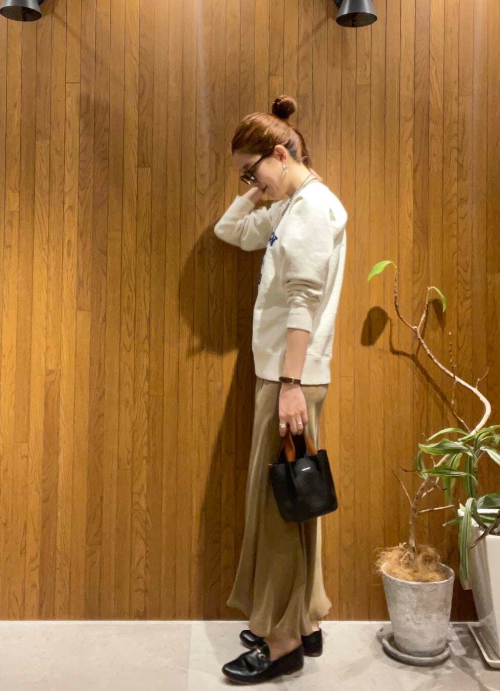 イエロー系のスカート、ベージュ系のスウェットを着用したレディースの冬コーディネートの2枚目の写真