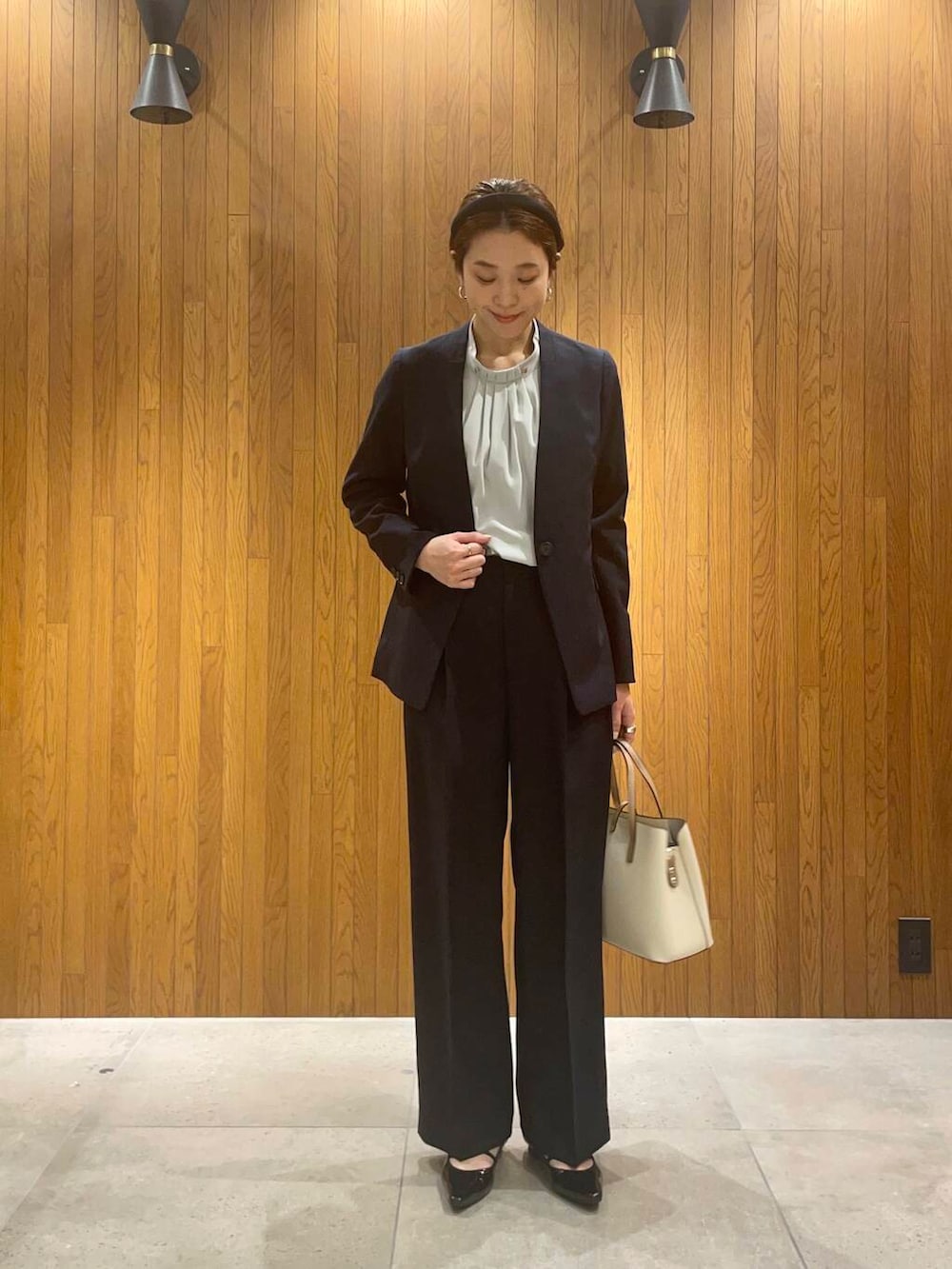 ホワイト系のトートバッグ、ブルー系のその他パンツ、ブルー系のノーカラージャケットを着用したレディースの冬コーディネートの2枚目の写真