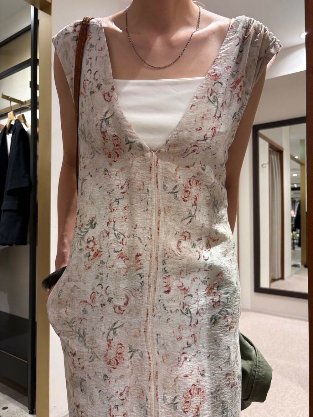 ホワイト系のキャミソール、その他のワンピース、ブルー系のデニムパンツを着用したレディースの夏コーディネートの5枚目の写真