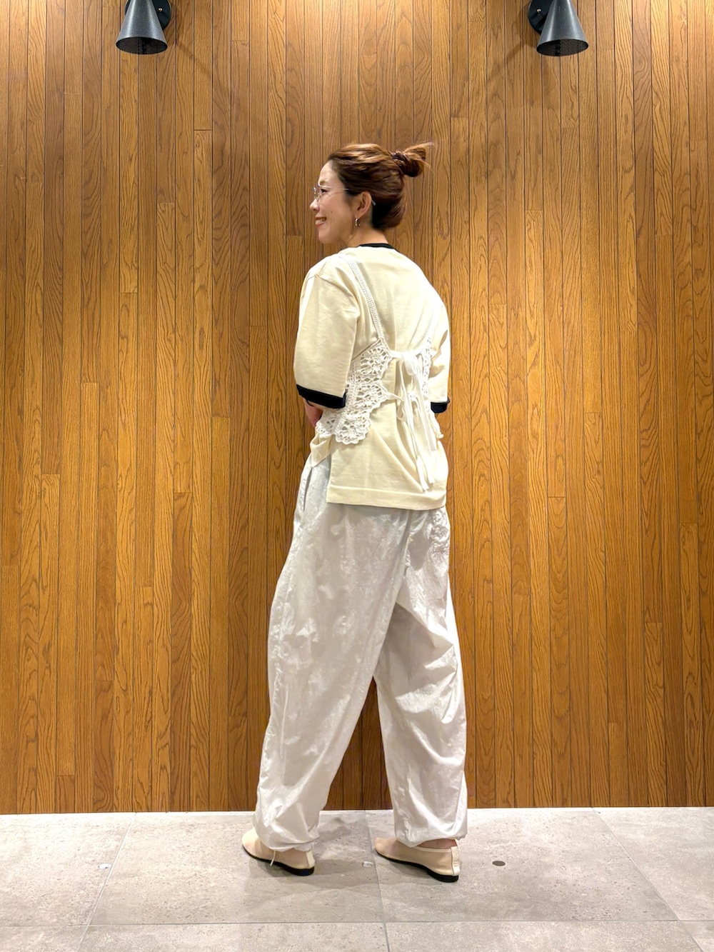 ホワイト系のニット/セーター、グレー系のその他パンツ、ブラック系のショルダーバッグを着用したレディースの夏コーディネートの6枚目の写真