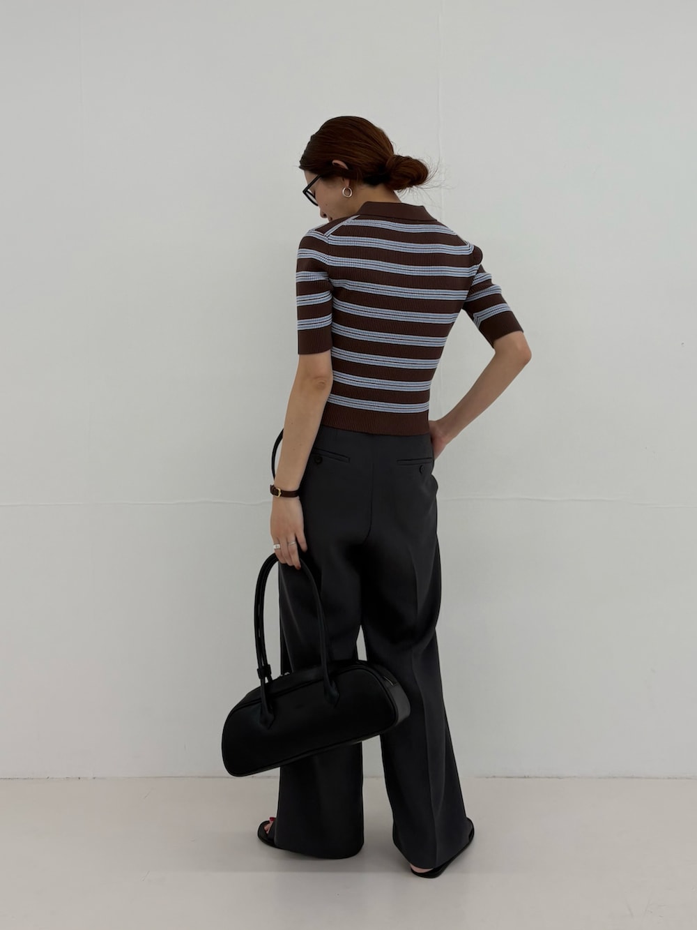 グレー系のその他パンツ、ブラウン系のニット/セーター、ブラック系のショルダーバッグを着用したレディースの春コーディネートの3枚目の写真