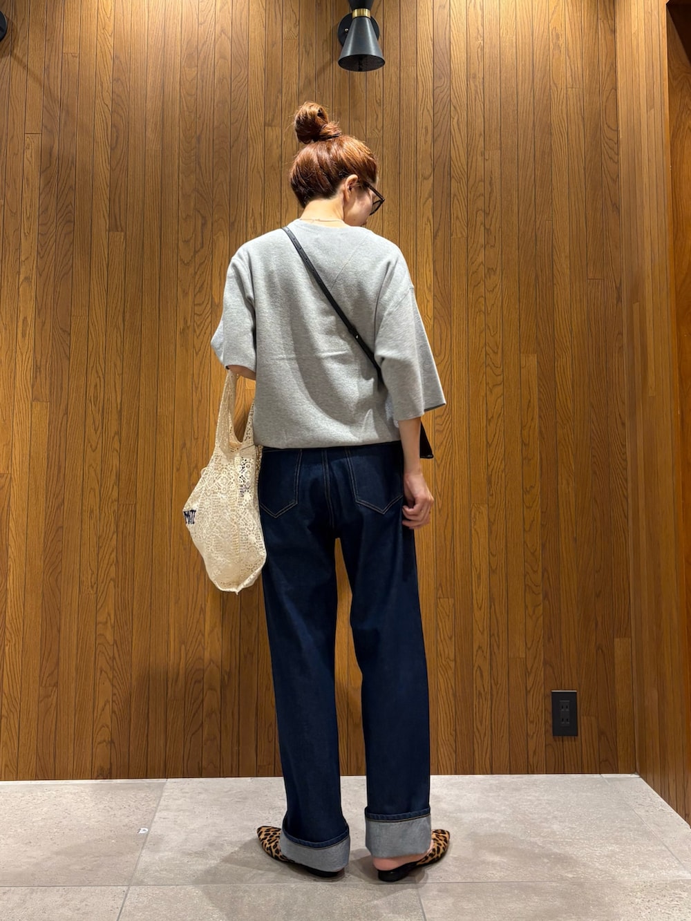 ホワイト系のハンドバッグ、ブルー系のデニムパンツ、ブラック系のショルダーバッグを着用したレディースの秋コーディネートの3枚目の写真