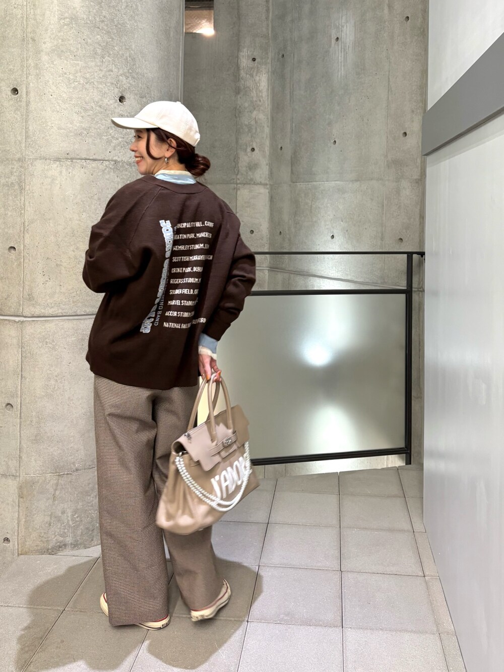 イエロー系のその他パンツ、ブルー系のTシャツ/カットソー、ベージュ系のハンドバッグを着用したレディースの秋コーディネートの7枚目の写真