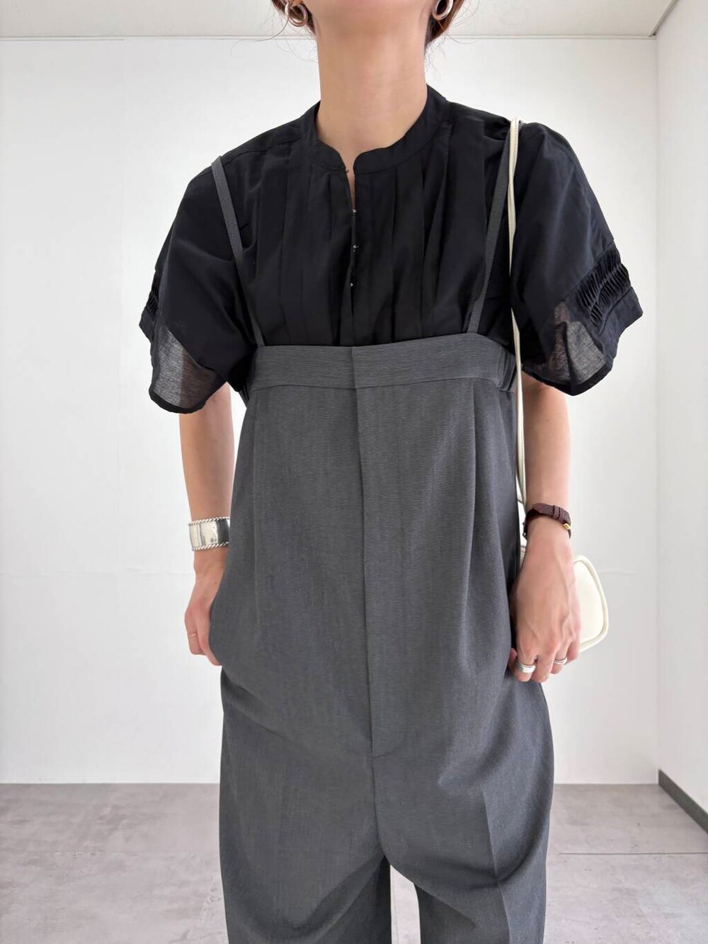 グレー系のサロペット/オーバーオール、ホワイト系のショルダーバッグ、ブラック系のサンダルを着用したレディースの夏コーディネートの4枚目の写真