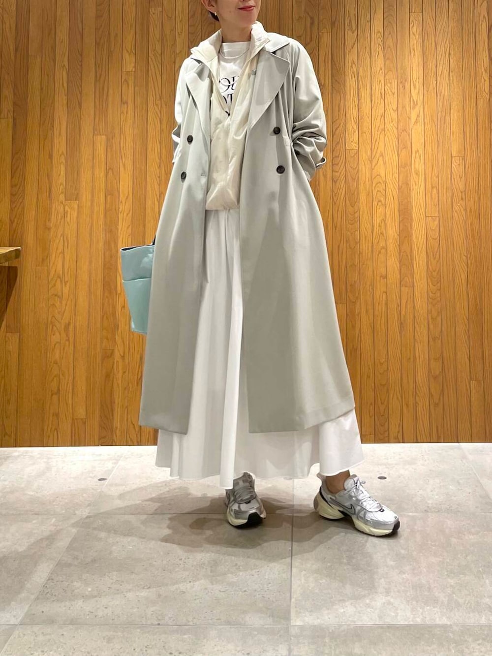 グリーン系のトレンチコート、その他のTシャツ/カットソー、ホワイト系のスカートを着用したレディースの春コーディネートの2枚目の写真