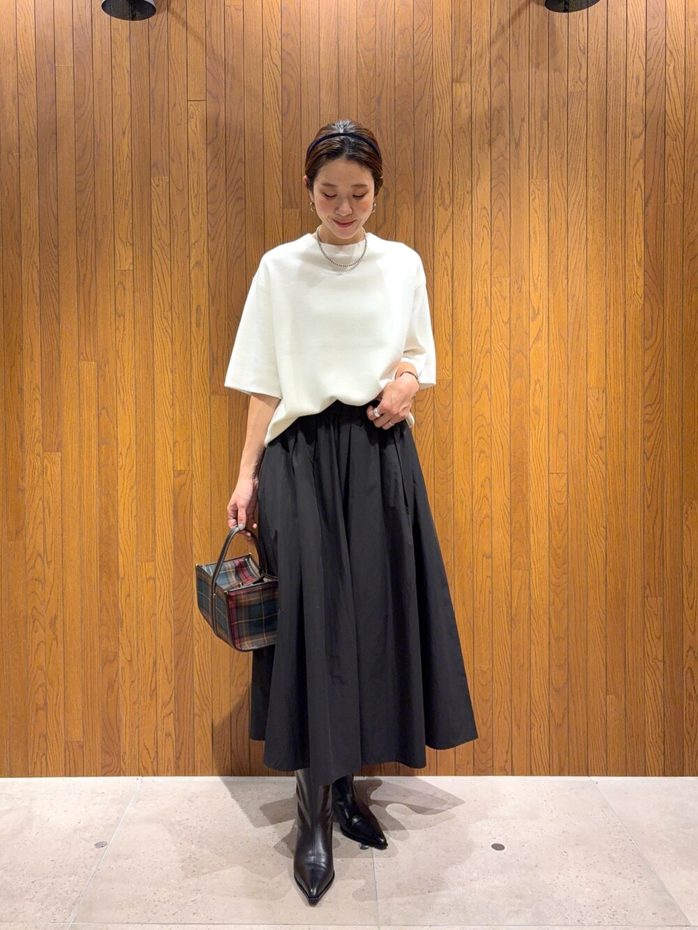 ホワイト系のニット/セーター、ブラック系のブーツ、ブラック系のスカートを着用したレディースの秋コーディネートの4枚目の写真