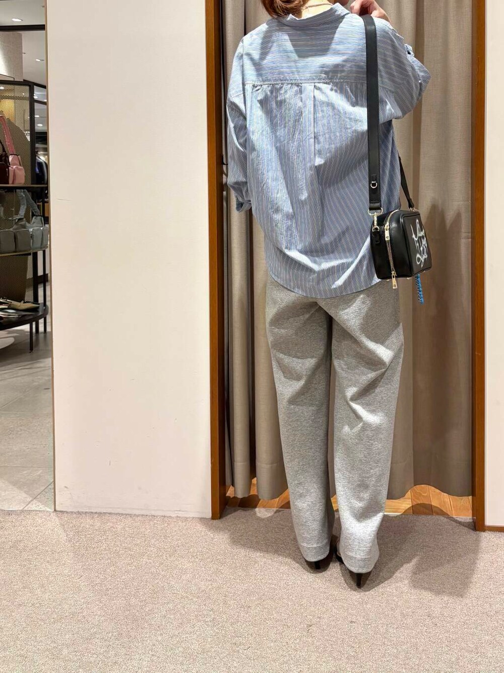 ブルー系のシャツ/ブラウス、ブラック系のショルダーバッグ、グレー系のその他パンツを着用したレディースの春コーディネートの4枚目の写真